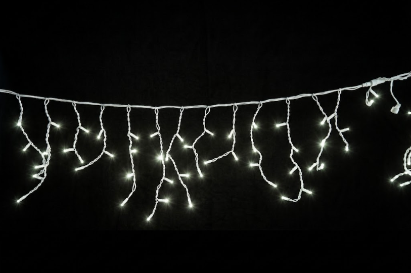 Kallvit LED-istappslinga monterad längs husfasad med blinkande ljuseffekt som skapar en gnistrande och elegant vinter- och julbelysning.